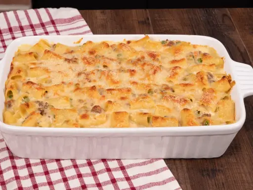 Un invitante pasta al forno bianca, con maccheroni dorati, piselli e carne macinata, gratinata al punto giusto.