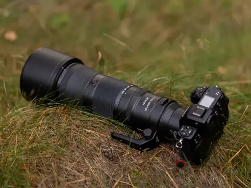 Profesjonalny aparat Nikon Z8 z obiektywem Nikkor 180-600mm leży na trawie. To co to jest aparat, to narzędzie do uwieczniania chwil.