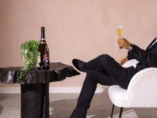 Ein Mann im Anzug genießt Champagner. Die aufwendige Herstellung erklärt, warum ist Champagner so teuer.