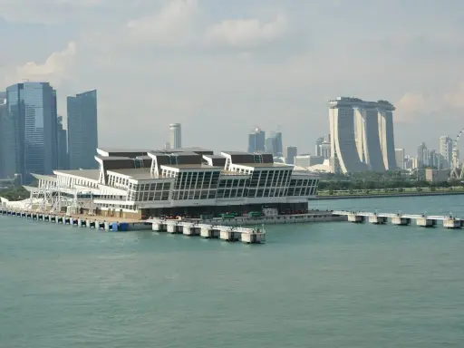 Moderno terminal crociere galleggiante nel **singapore porto**, con grattacieli iconici sullo sfondo.