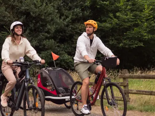 Para wycieczka rowerowa z dzieckiem w przyczepce. Zastanawiasz się, jakie buty na rower będą najlepsze? Oni wybrali wygodne sportowe obuwie.