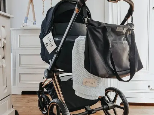 Stylowe wyposażenie wózka dla noworodka: czarna torba i miękki kocyk Tiny Star.