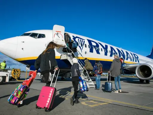 Ludzie wsiadają do samolotu Ryanair z bagażami. Zastanawiasz się, czy można zwrócić bilety Ryanair?