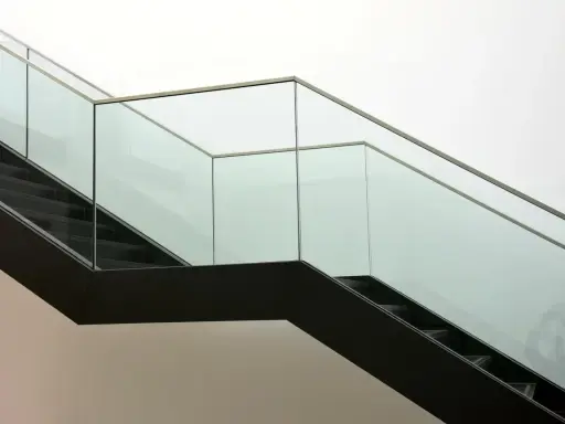 Escalera moderna con barandillas de cristal. ¿Cómo saber si un cristal es templado? La seguridad es clave.