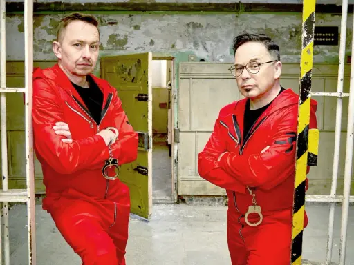 Dwóch mężczyzn w czerwonych kombinezonach i kajdankach, gotowych do ucieczki. Czy uda im się unlock po polsku?