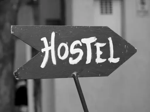 Piltavla med texten "Hostel" i vit färg, pekar åt höger. Enkel skylt som leder dig till ditt vandrarhem i Dalsland.