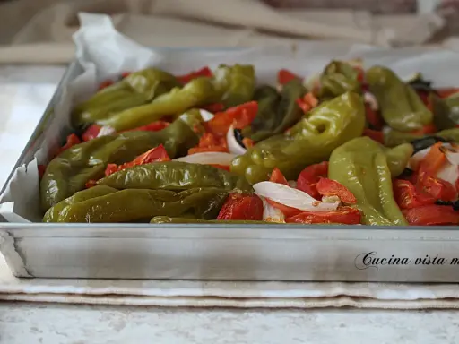 Friggitelli al forno con pomodoro e cipolla, un contorno saporito e colorato, pronto per essere gustato.