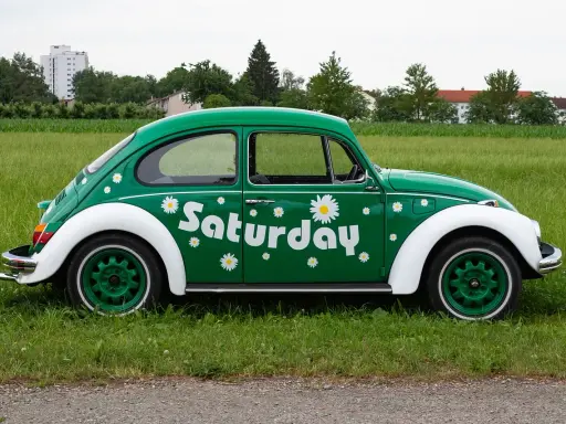 Zielony Garbus z napisem "Saturday" i stokrotkami. Idealny na dzień wolny za święto w sobotę.