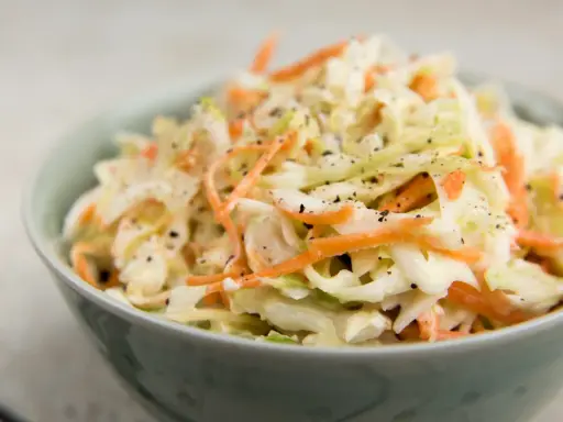 Krämig coleslaw med strimlad vitkål och morot, perfekt till grillat. Ett enkelt coleslaw recept för alla tillfällen.
