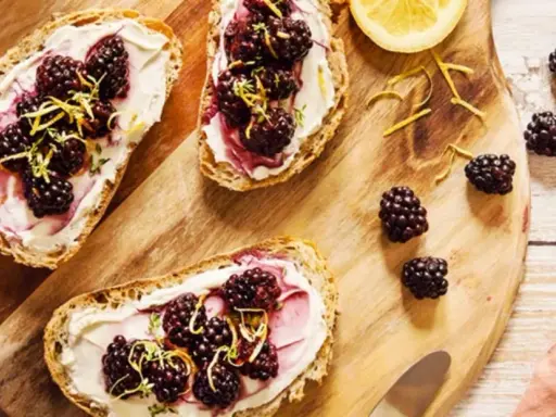 Tartines de pain grillé avec fromage frais, mûres et zeste de citron. Un encas healthy et gourmand, parfait pour un petit-déjeuner ou une pause.