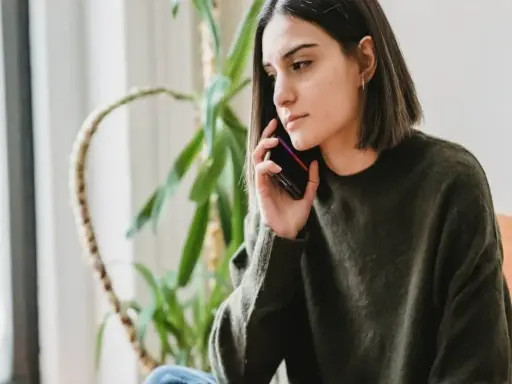Zmartwiona kobieta rozmawia przez telefon, zastanawiając się, czy pracodawca może cofnąć urlop.