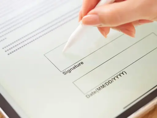 Mano firmando un contrato de arrendamiento digitalmente en una tableta con un lápiz óptico.