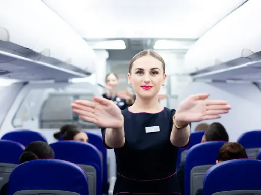 Uśmiechnięta stewardessa Wizzair wita pasażerów. Czy trzeba drukować kartę pokładową Wizzair? Sprawdź przed podróżą!