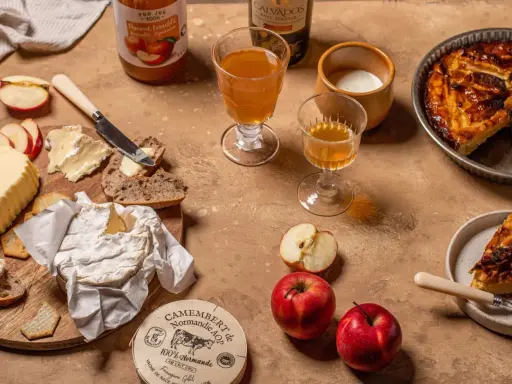 Un plateau gourmand avec camembert, pain, beurre, pommes et tarte aux pommes, une spécialité normandie.