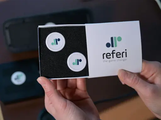 Scatola con due gettoni e logo "referi", un segnapunti online gratis per cambiare il gioco.