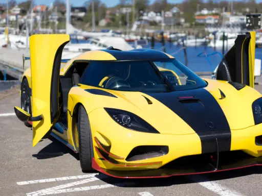Gelber Koenigsegg Agera RS mit geöffneten Türen am Hafen, bereit für eine Spritztour.
