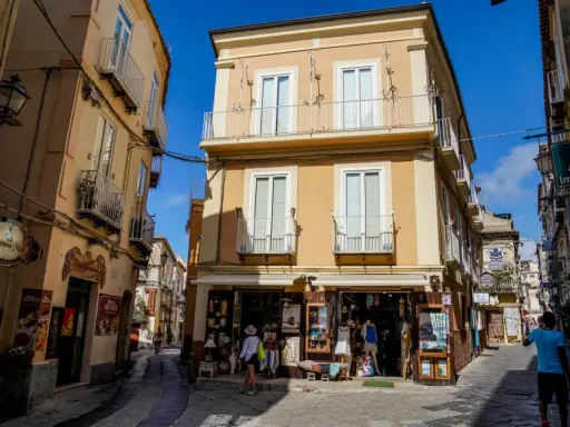 Un vicolo di Tropea con negozietti e palazzi color ocra, un'atmosfera che ricorda la porta vaticana.
