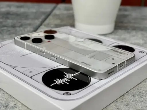 Przezroczysty telefon survivalowy z minimalistycznym designem, leżący na białym pudełku z grafiką.