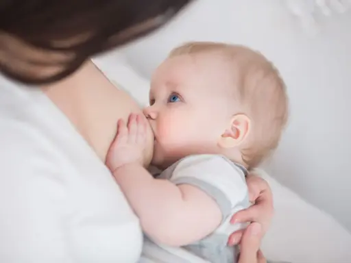 Niebieskooki niemowlak karmiony piersią. Czasem pojawia się kryzys laktacyjny, ale to naturalny etap.
