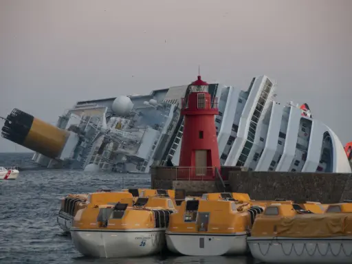 Épaves du Costa Concordia, symbole tragique de la mer. Des canots de sauvetage orange attendent, rappelant le naufrage et ses morts.