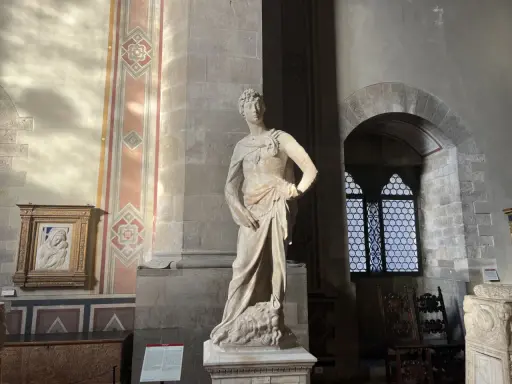 Statue de David par David Verrocchio, debout sur la tête de Goliath, dans un musée.