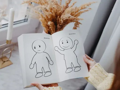 Otwarta książka pokazuje rysunki smutnego i radosnego dziecka, symbolizujące nasze wewnętrzne dziecko.