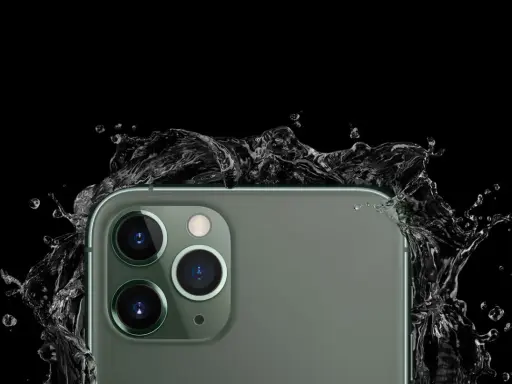 El iPhone 11, con sus cámaras de 12 megapíxeles, resiste salpicaduras de agua en un fondo negro.