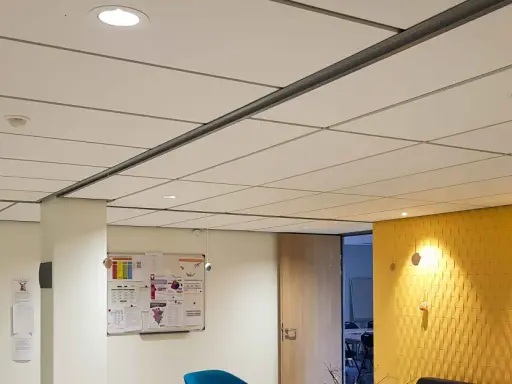 Plafond fibralith blanc, discret, avec des spots lumineux intégrés. Une ambiance moderne et épurée.