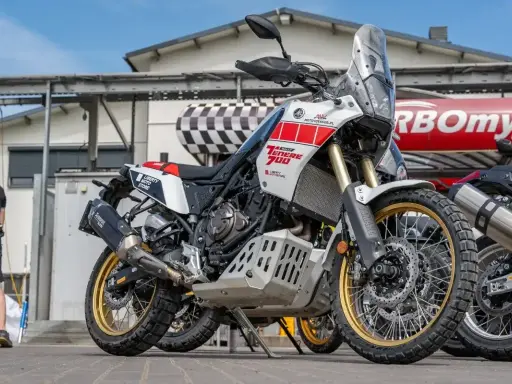 Biały motocykl Yamaha Ténéré 700 z czerwonymi akcentami, gotowy na przygodę. Dane techniczne tego modelu zachwycają.