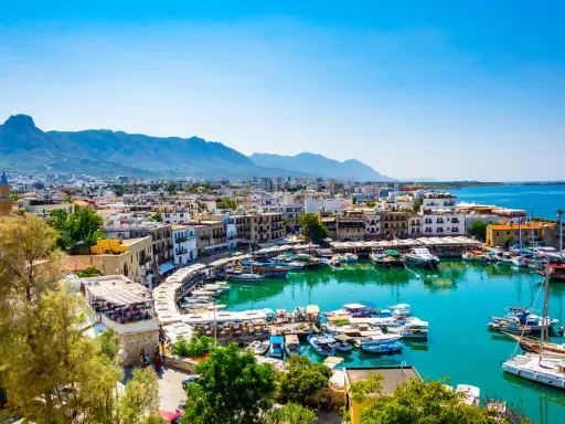 Kyrenia, Cypr, gdzie najcieplej, z malowniczym portem pełnym łodzi i górami w tle.