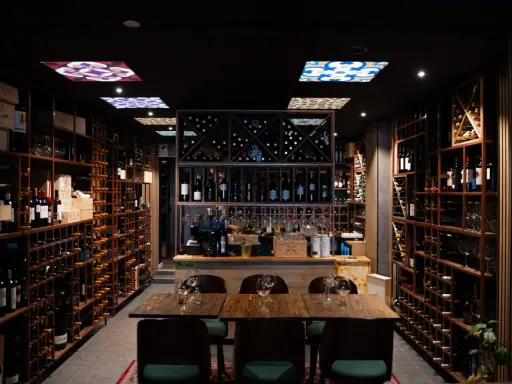 En vinbar med hyllor fyllda med flaskor, redo för en kväll med pasion tapas och goda viner.