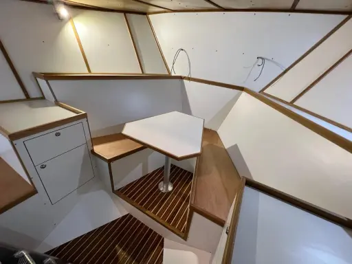 Modern båt inredning inspiration med vit och trädetaljer. En unik bordlösning och smarta förvaringsutrymmen.