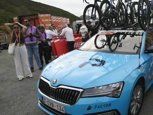 Blaues Auto mit Fahrrädern auf dem Dach, bereit für ein Rennen. Auf der Motorhaube steht "PREMIER TECH", ein Zeichen für israelische Spitzentechnologie im Radsport.