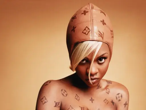Lil' Kim w skórzanej czapce i z tatuażami Louis Vuitton na ciele.
