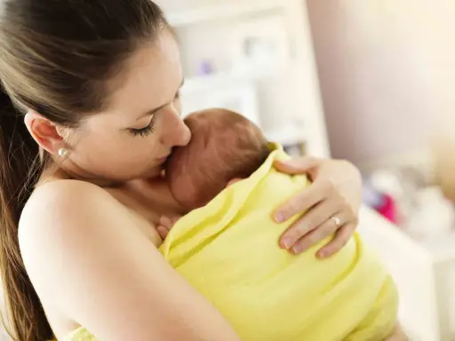 Un tenero abbraccio tra madre e neonato, un esempio di attaccamento alla madre psicologia, che crea un legame indissolubile.