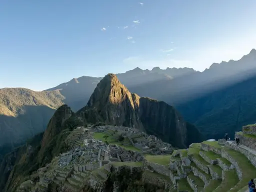 Machu Picchu i Peru, med solstrålar som bryter igenom molnen. En resa hit kan kräva vaccination Peru.