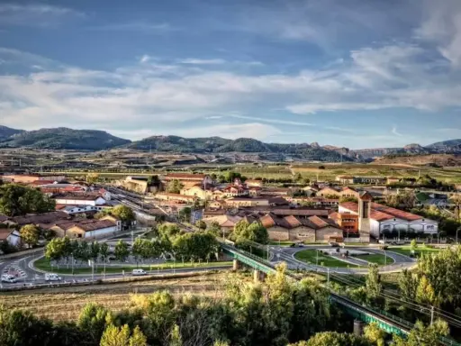 Vista aérea de un pueblo con tejados rojos y montañas al fondo. Se ve la bodega RODA, un buen lugar para añada 2017 rioja.