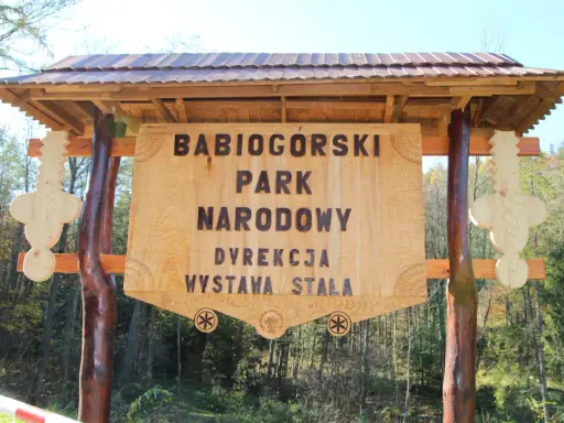 Drewniana brama z napisem "Babiogórski Park Narodowy" zaprasza do odkrywania **zawoja atrakcje**.