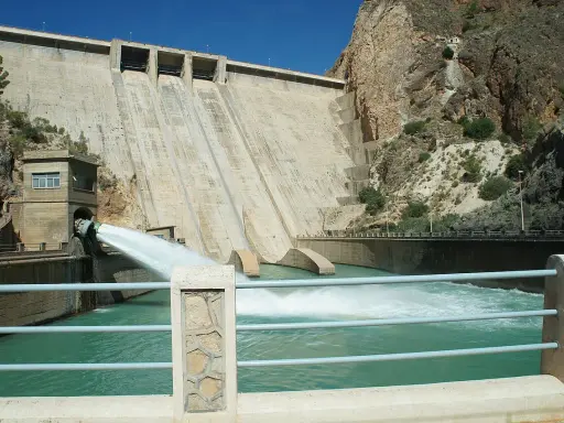 El embalse del Cenajo libera agua a través de un gran conducto, creando una cascada espumosa en el río.