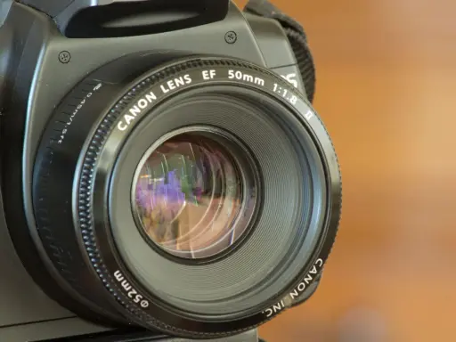 La fotocamera sfocata dopo caduta mostra un obiettivo Canon EF 50mm 1:1.8.