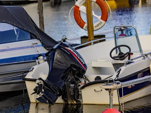 Moteur Mercury hors-bord sur un bateau blanc. Le moteur 2 temps ne démarre pas, il est temps de le réparer.