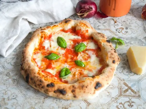 Frisch gebackene neapolitanische Pizza mit geschmolzenem Käse und Basilikum. Die perfekte neapolitanische Pizza Temperatur sorgt für den typischen fluffigen Rand.