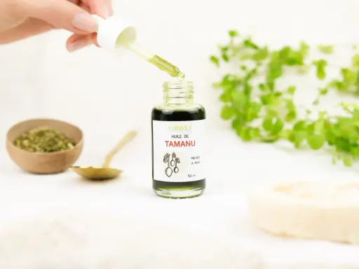 Goutte d'huile de tamanu tombant d'une pipette dans un flacon. Le produit est naturel, mais il faut connaître les effets secondaires de l'huile de tamanu.