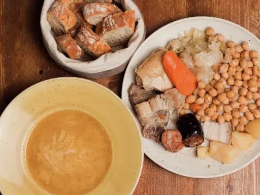 Un plato de comida típica de Madrid: cocido con garbanzos, carnes, verduras y pan.