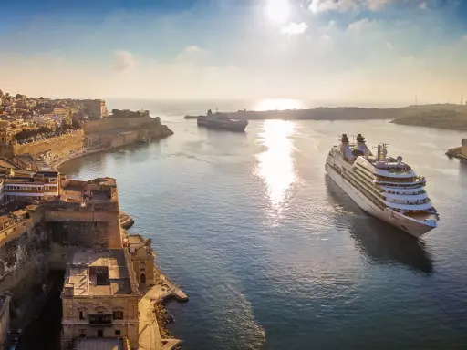 MSC Crociere: documenti di viaggio pronti per una crociera al tramonto tra fortezze storiche e navi maestose.