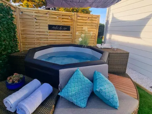 Ambiance relaxante autour d'un spa gonflable : coussins bleus, serviettes douces et guirlande lumineuse pour une deco parfaite.
