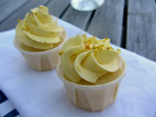 Två läckra citron cupcakes med gul frosting och strössel. Perfekt för en fika.