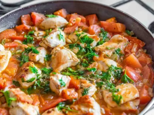 Succulento pollo alla pizzaiola in padella, con pomodoro fresco e prezzemolo. Un piatto saporito e invitante.