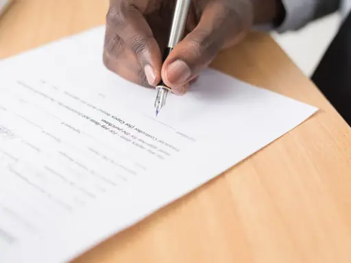 Dłoń podpisuje dokument, być może jeden z rodzajów intercyzy.
