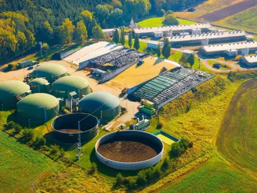 Planta de biogás con biodigestores y granjas. Las desventajas de la biomasa incluyen el uso de grandes extensiones de tierra y la necesidad de infraestructura.